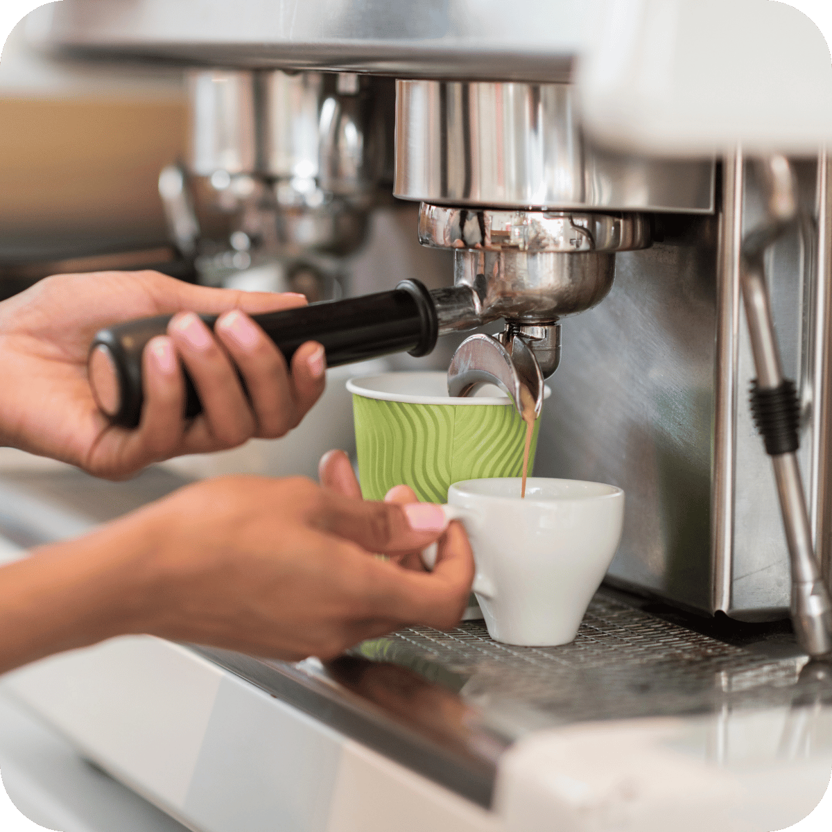 A person prepares an espresso from a professional coffee machine. 